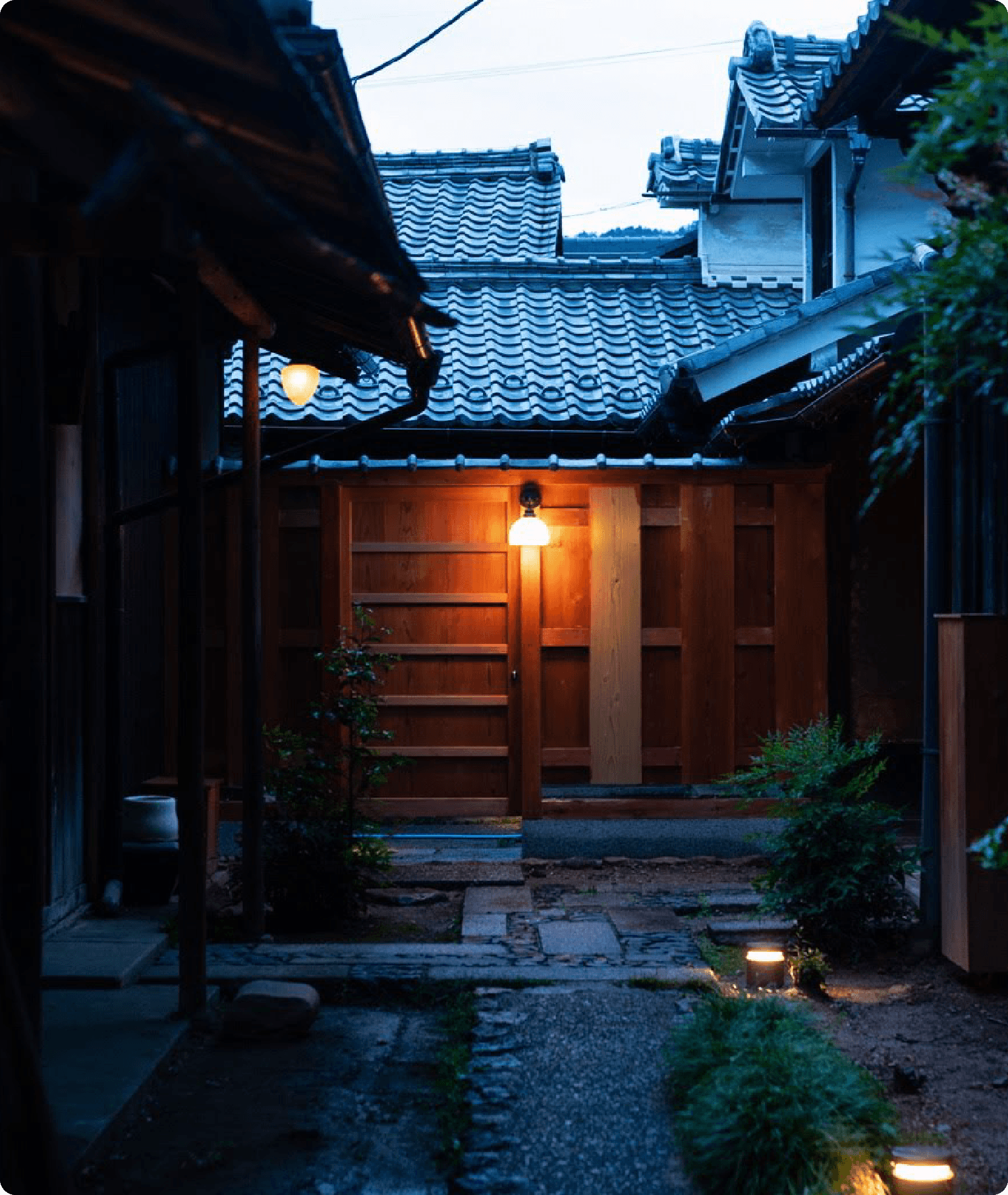 夕暮れに灯がともる町家の玄関
